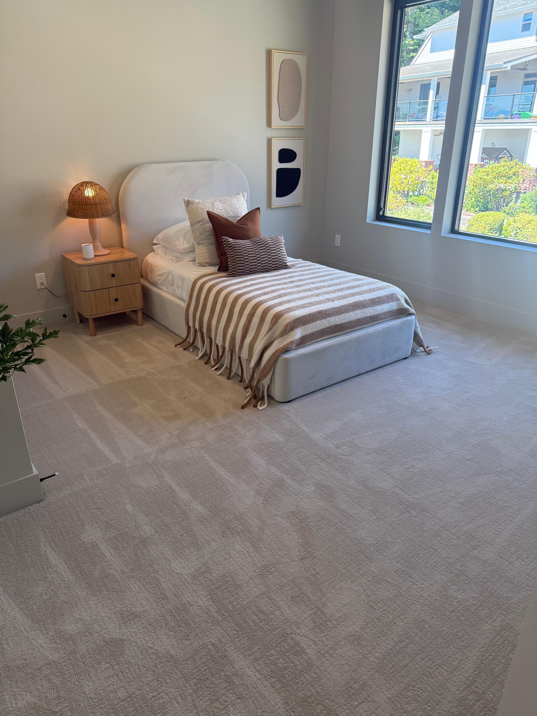 Soft cream carpet installation in bright guest bedroom with large windows and natural light — Skyview Flooring project in Bethany, OR