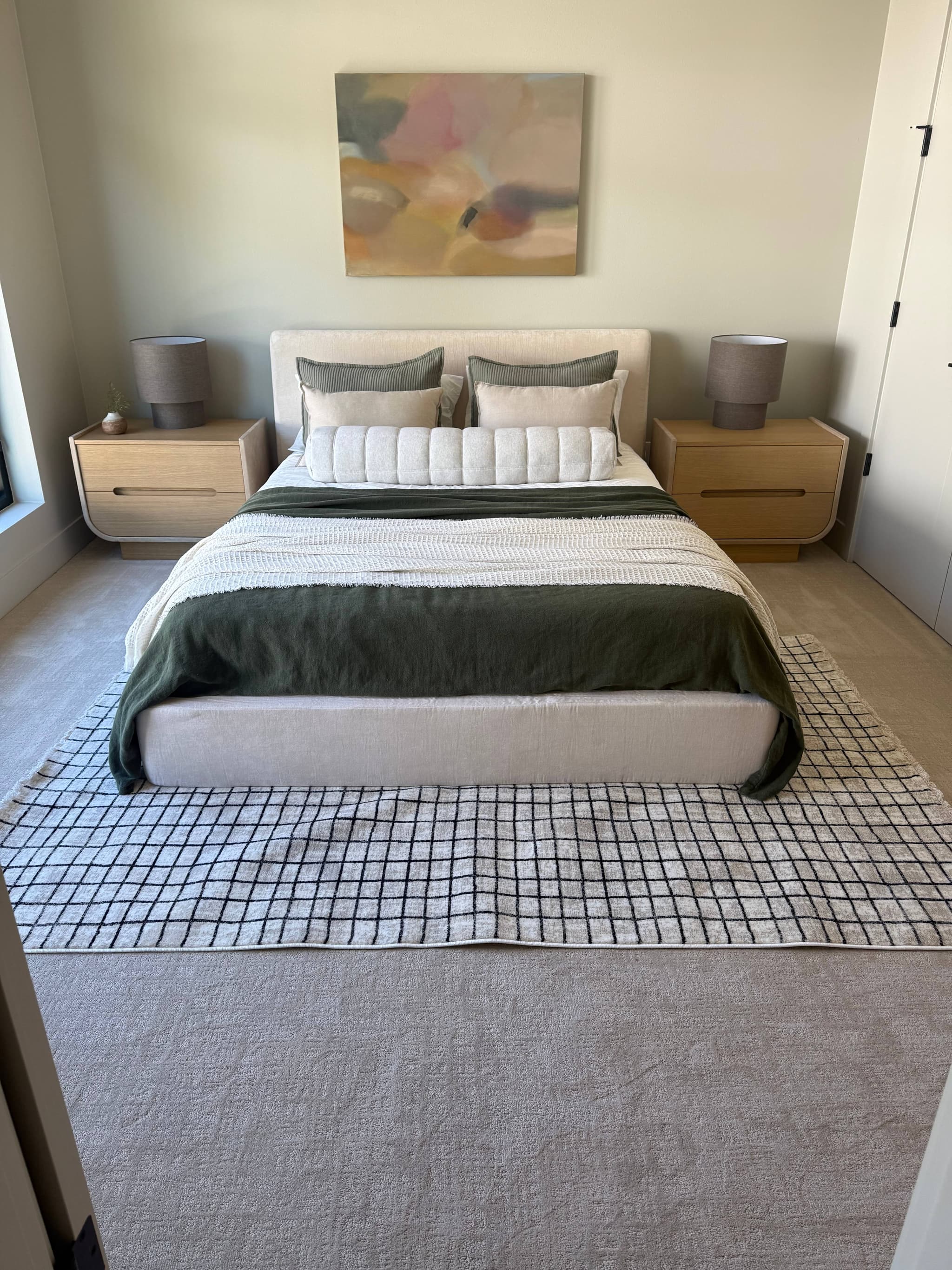 Plush neutral carpet installation in primary bedroom with upholstered bed and oak nightstands — Skyview Flooring project in Bethany, OR