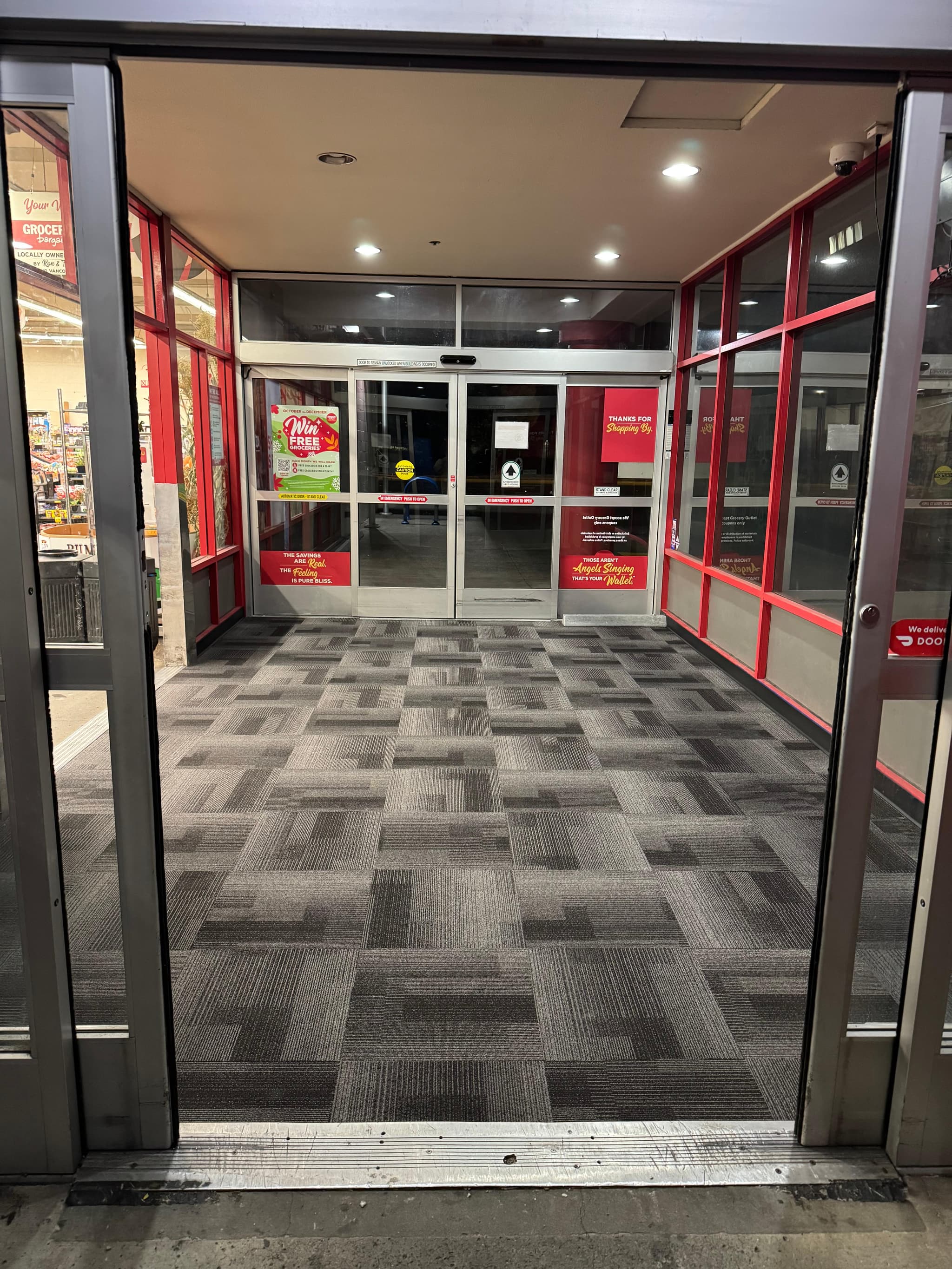 Gray patterned commercial carpet tile installed in a retail store entrance vestibule