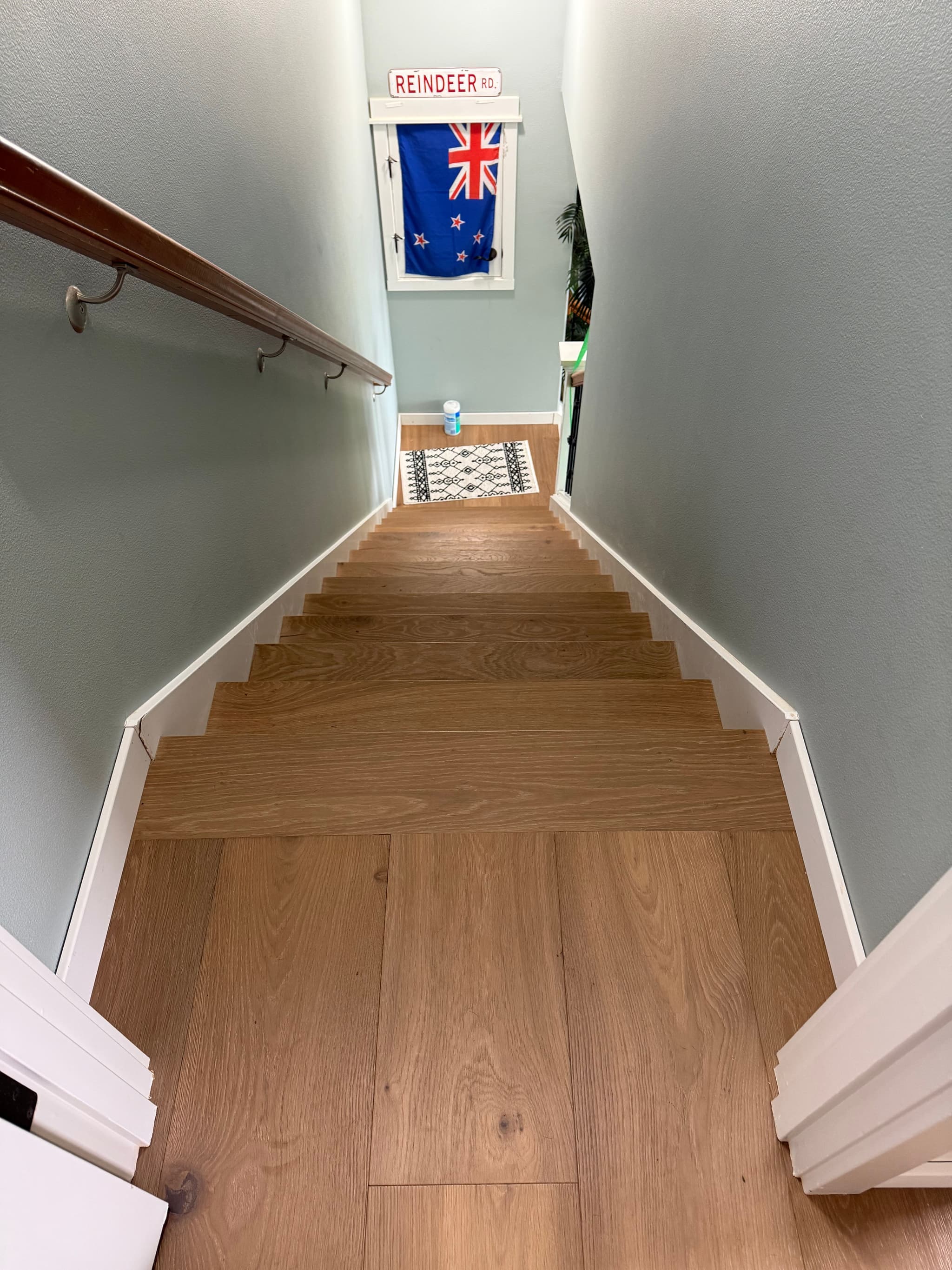 Engineered hardwood treads and risers on a narrow staircase leading down to the basement landing in a Ridgefield, WA home